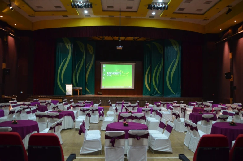 a group of tables sitting in front of a projection screen