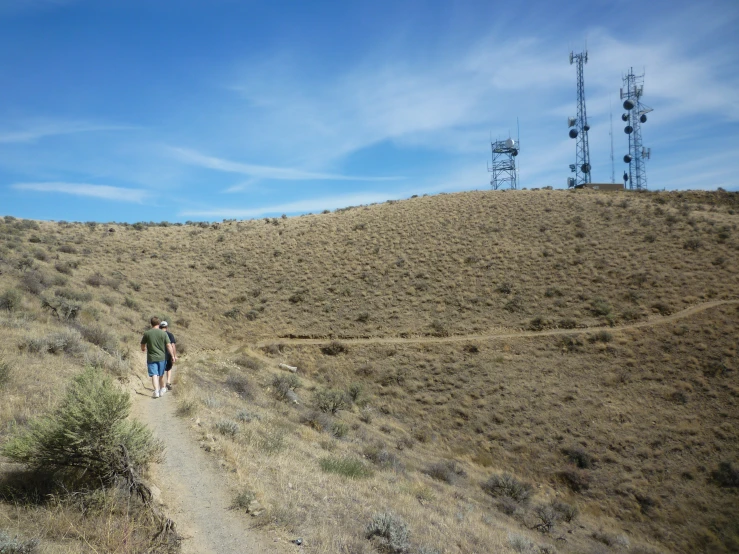 two men walk on an area of dry grass