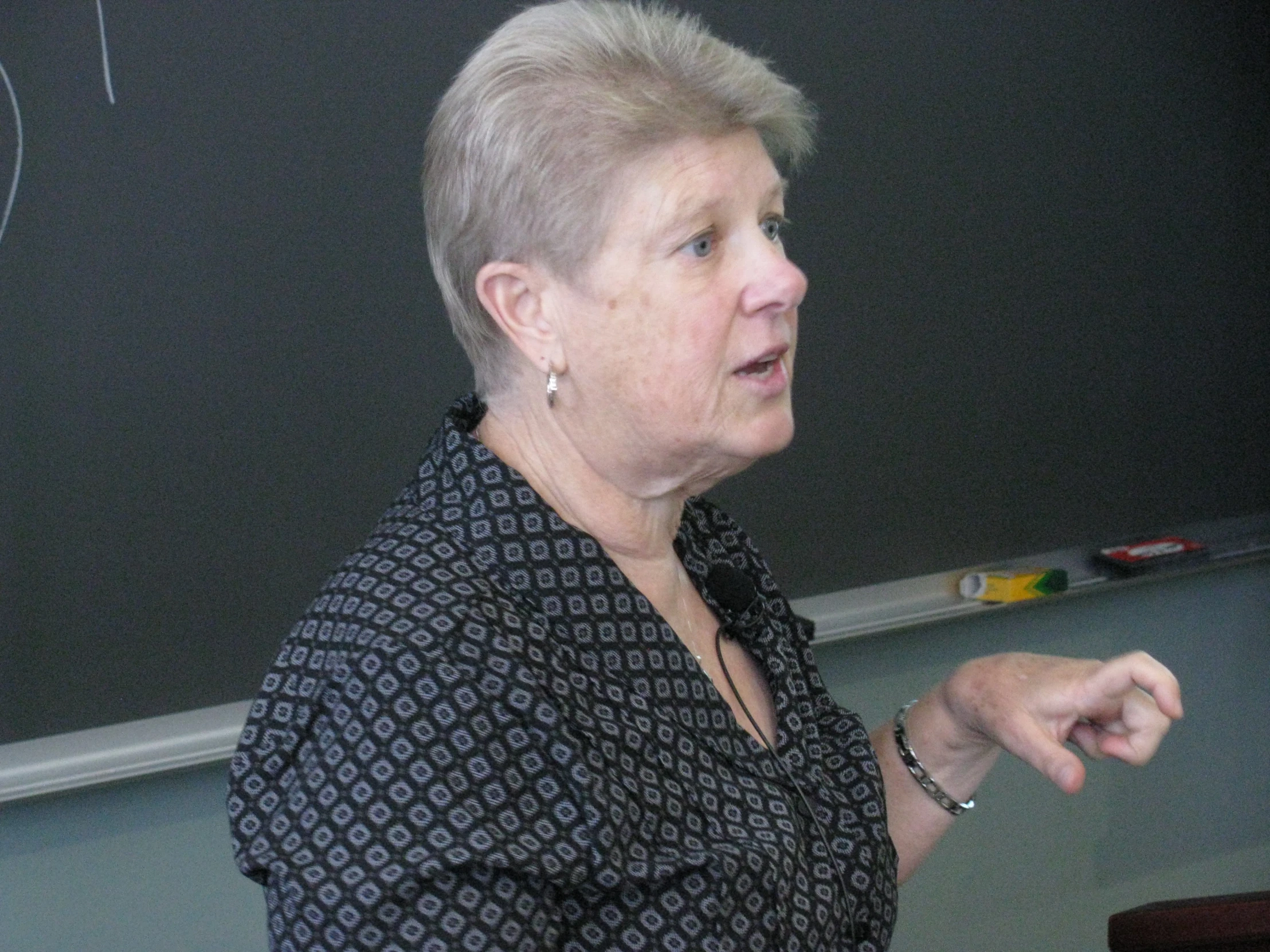 a woman holding a camera and speaking into a microphone