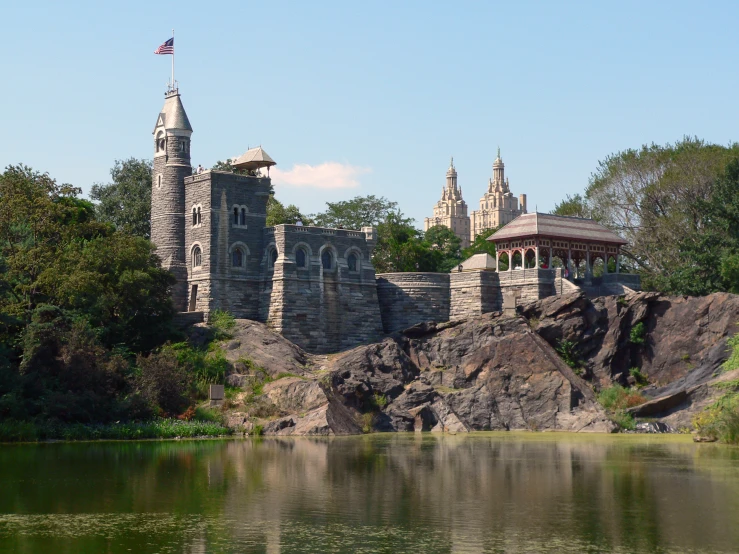 a castle and building are seen from across the lake