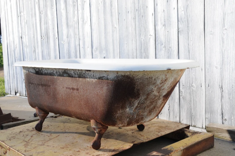 an old rusty tub sitting on the back of a cart