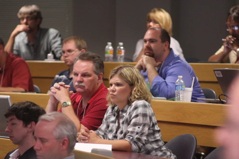 a group of people sitting in front of laptops