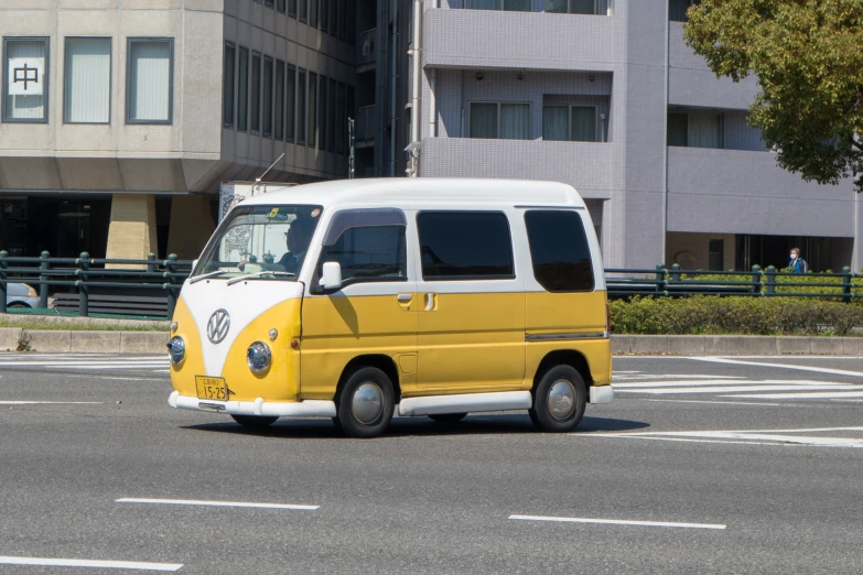 a small yellow and white van parked next to a building