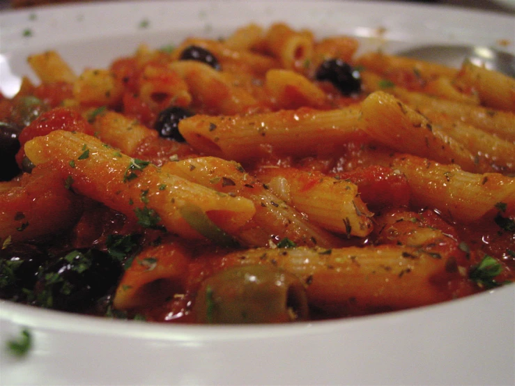 a bowl filled with pasta and tomatoes on top of a table