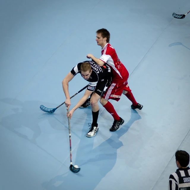 two people standing next to each other with a hockey stick