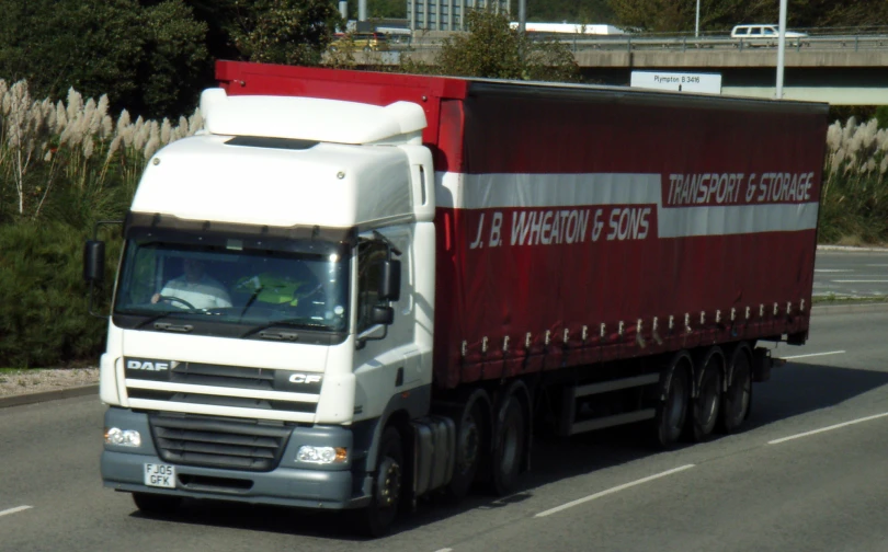 a large white red and black truck on the street