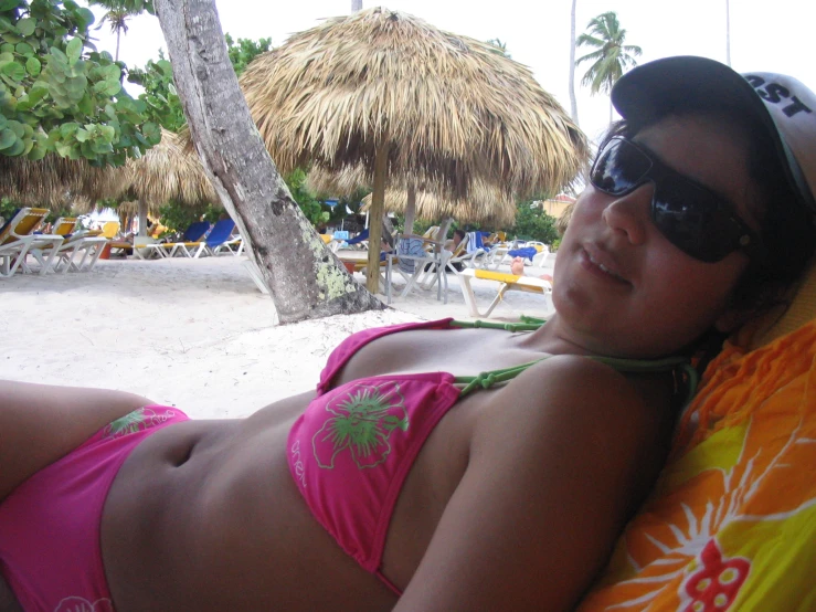 woman laying on the sand next to a beach in bikini