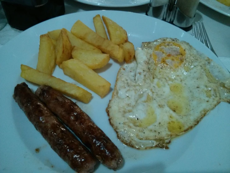 breakfast foods on plate with sausage, eggs and potatoes