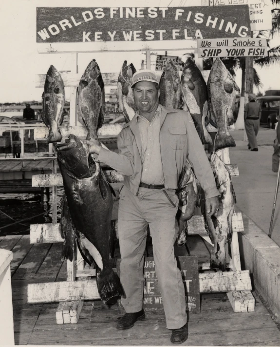 a man in military uniform sitting on wooden dock with fish