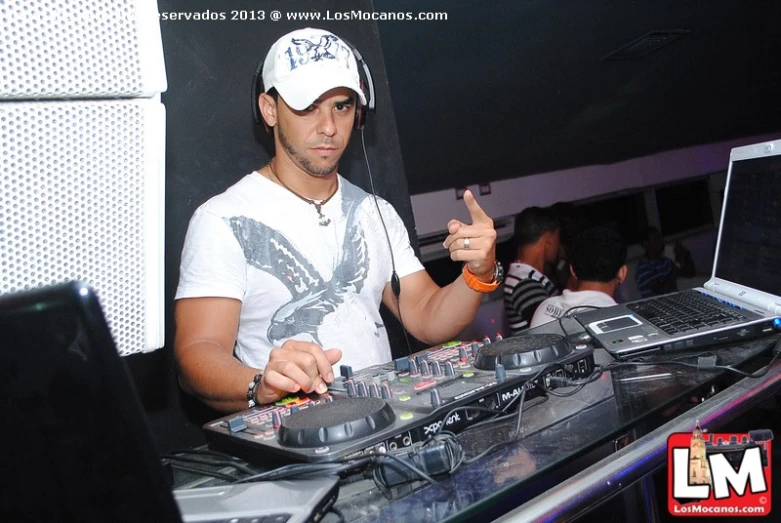 a man dj mixing at an event with a laptop computer