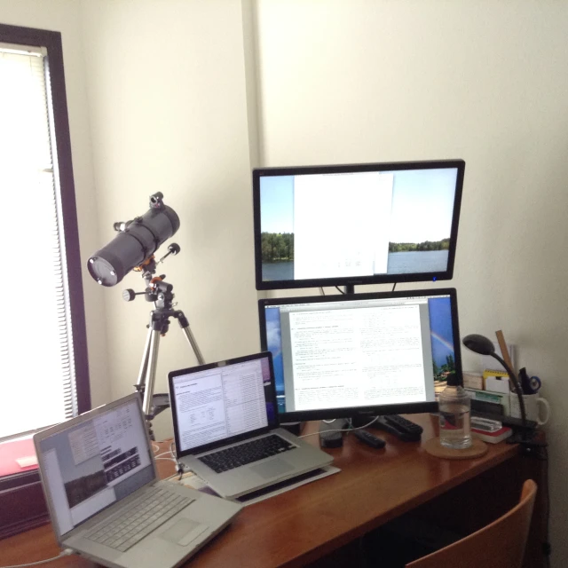 two laptops and a camera on a small table