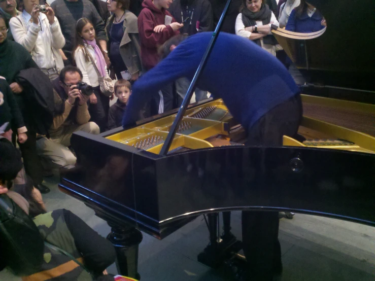 a man with a broom, is playing the piano