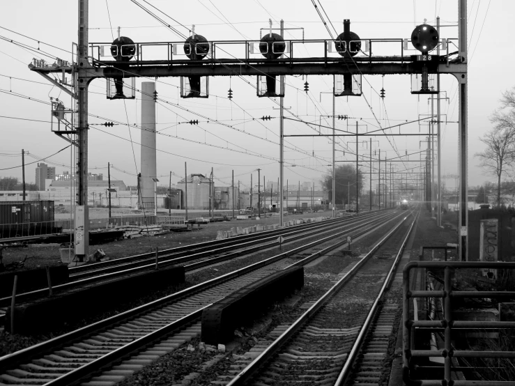 several rail road tracks and a train in the background