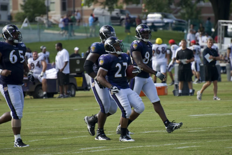 a football team holding a ball and running across the field