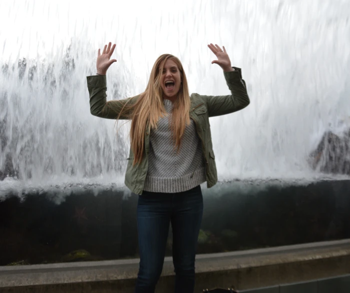 young woman having fun by fountain at outdoor gathering area