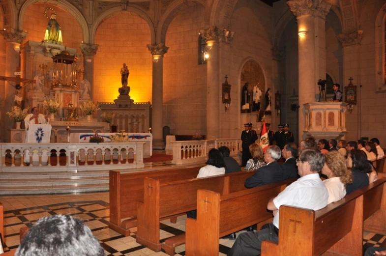 many people are sitting in pews inside of a church