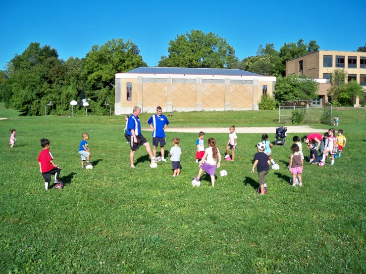 a group of children and an adult are standing in a field