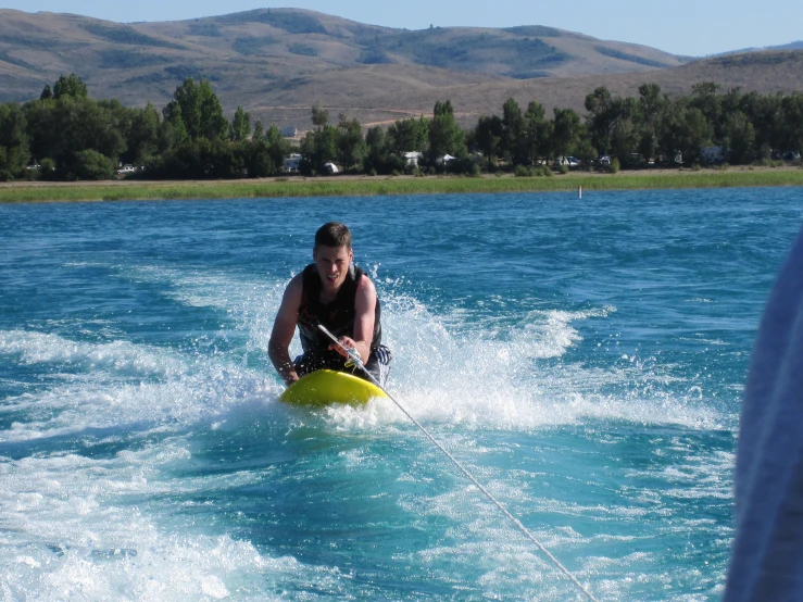 a person is being towed through some water on a boat