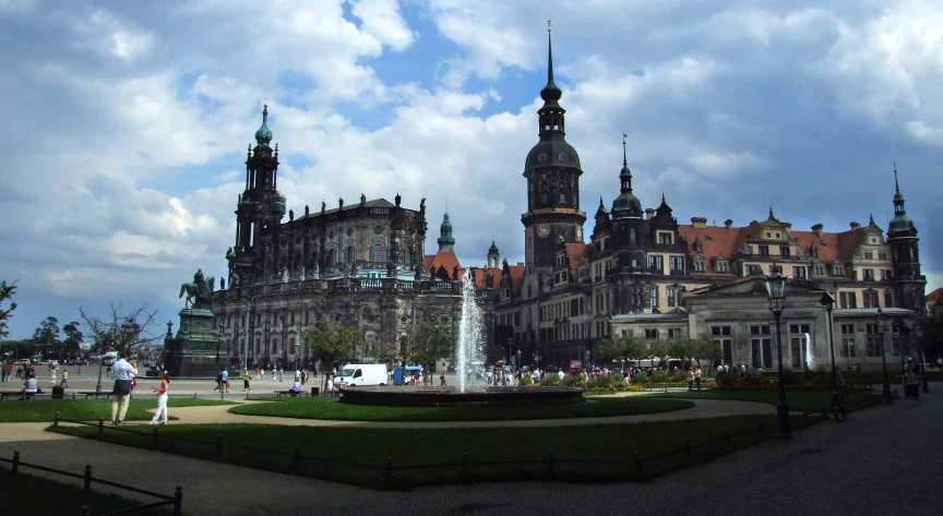 large old buildings with towers in front of a fountain