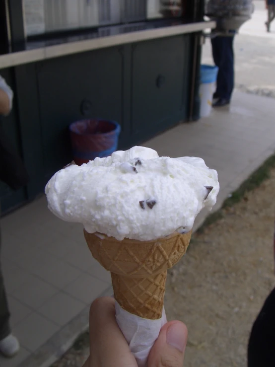 a person holds an ice cream cone in their hand