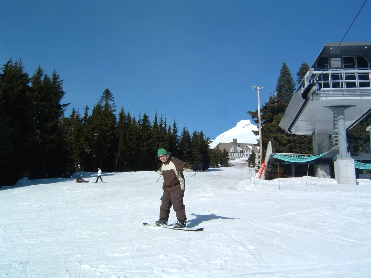 the person is snowboarding down the snowy hill