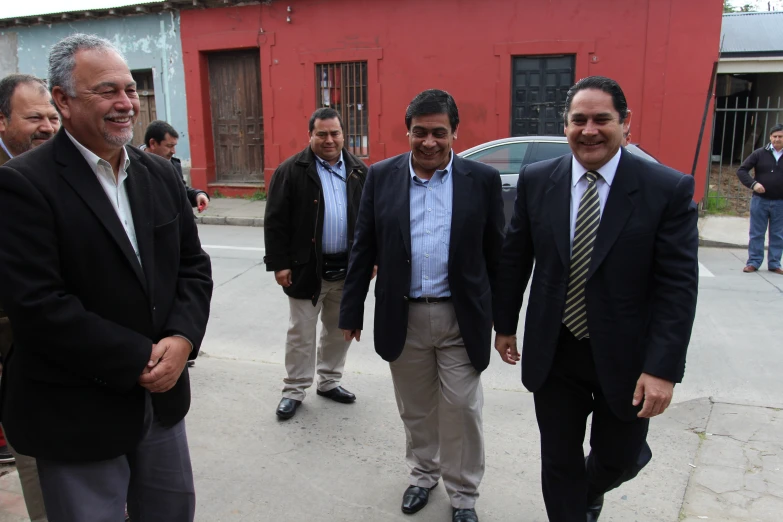 some men in business suits standing on the side of the road