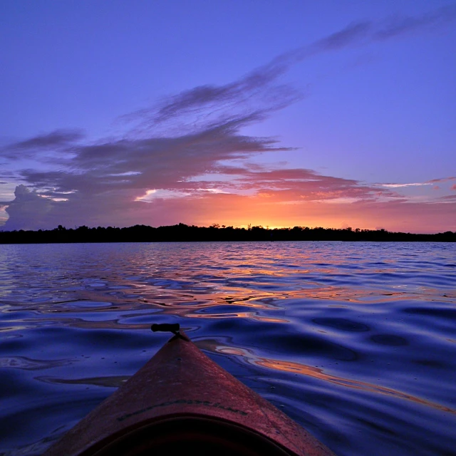 the view from the inside of a kayak at sunset