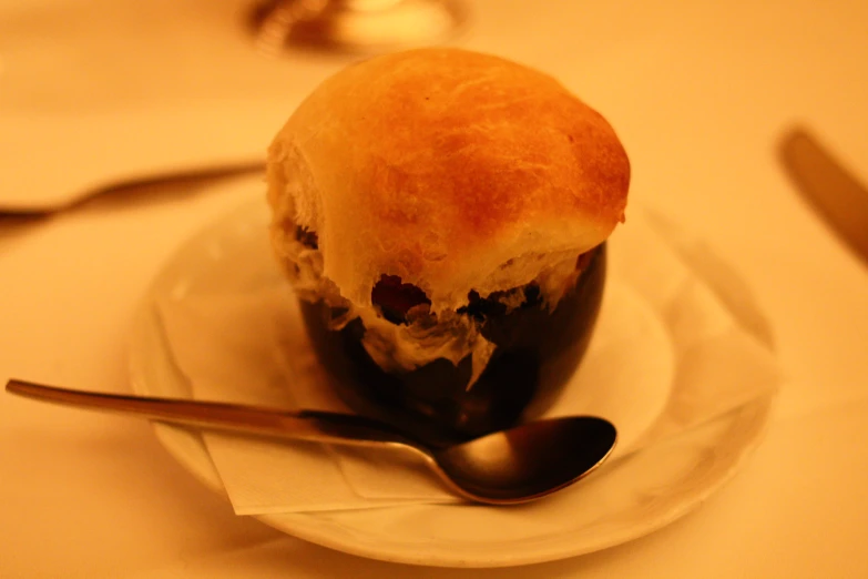 some bread is sitting on a plate with a spoon