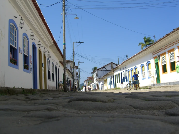 a person on a bicycle on a road in a small village