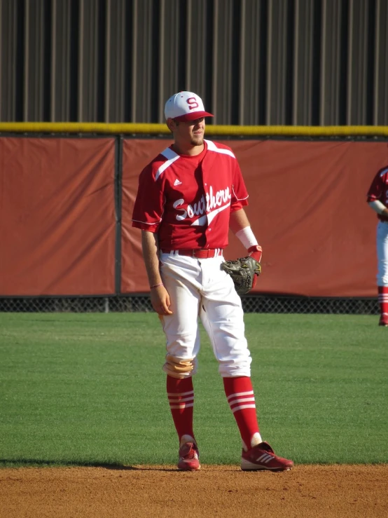 a baseball player standing in the outfield on a sunny day