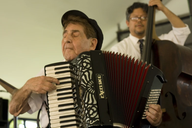 a man in a hat holding an accordion and playing an instrument