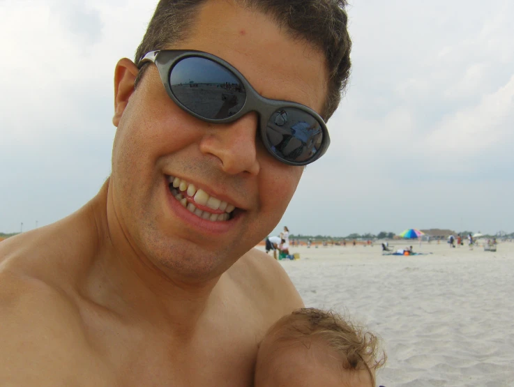 the young man is wearing sunglasses on a beach