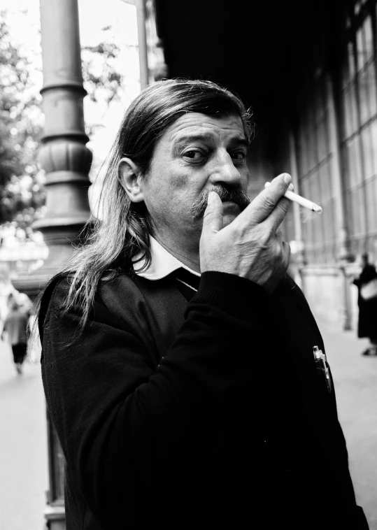 man smoking outside with no smoking cigarette and black and white image
