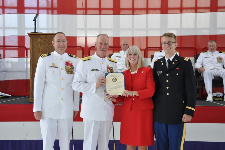 the military officers are presenting an award to the woman