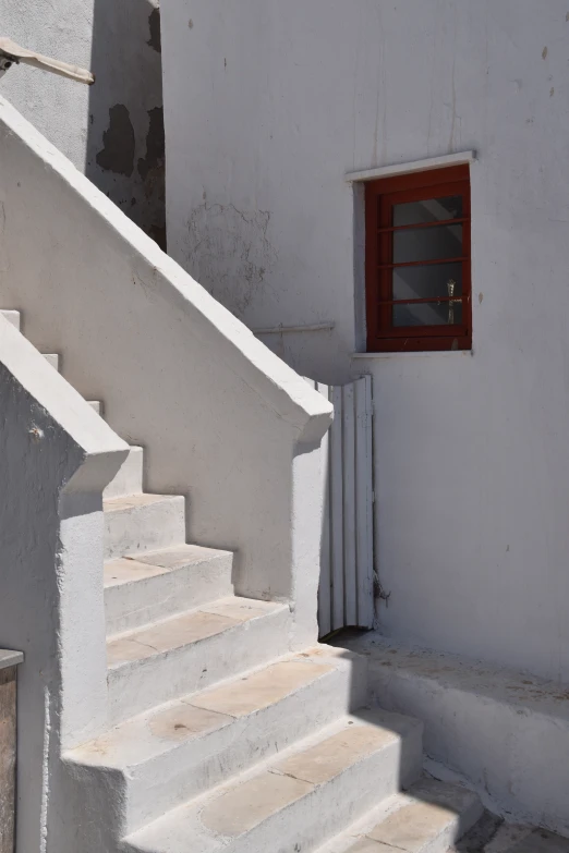 a white stair case with a red window