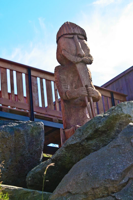 large and decorative wooden statue sitting in front of rocks