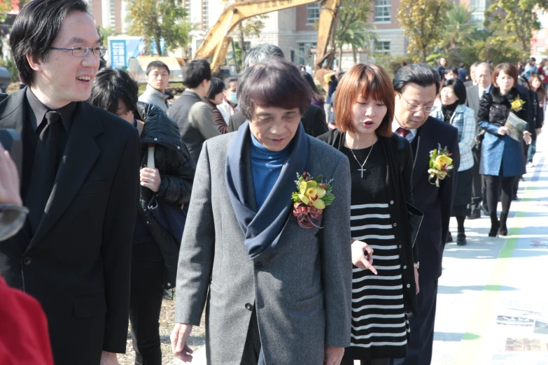 the people in business attire walk together down the sidewalk