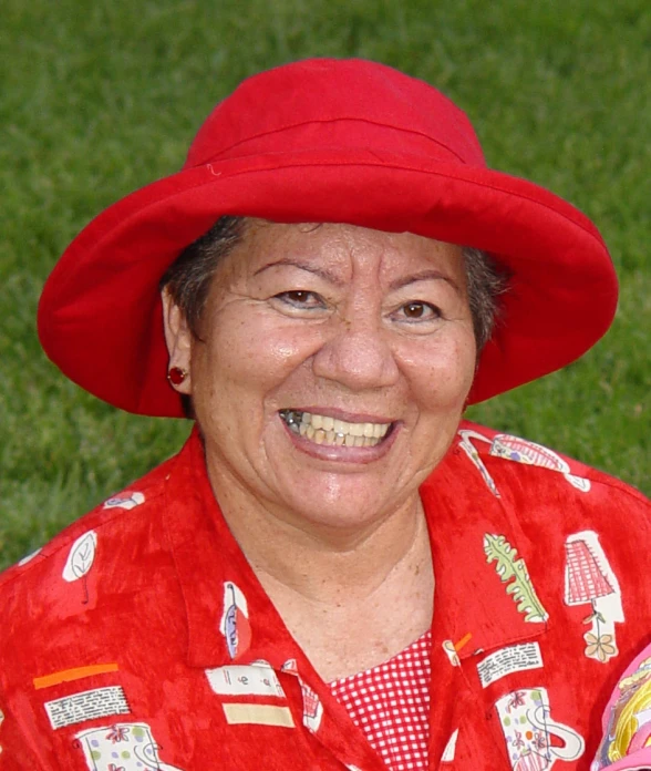 an older woman wearing a red hat is smiling