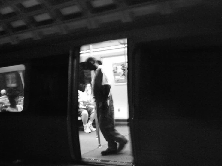 a man in long pants walking toward the subway