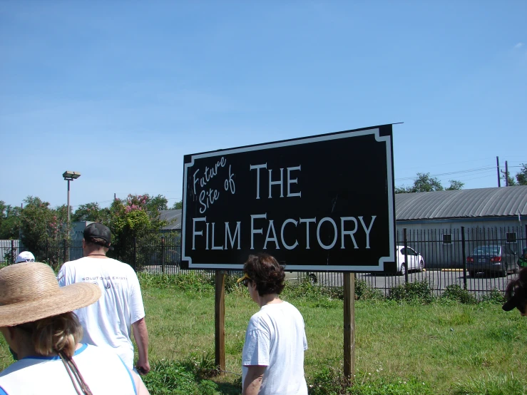 a group of people stand around a sign