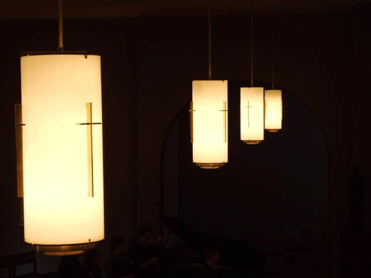 lights hanging from a ceiling with people in the background