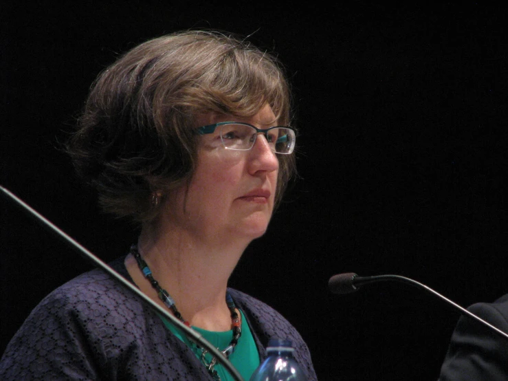 a woman at a conference speaking into a microphone