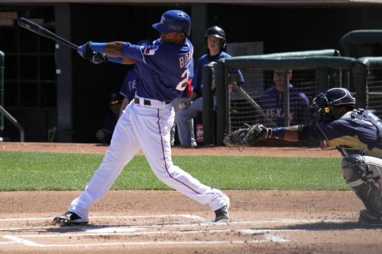 a baseball player swinging his bat on home plate