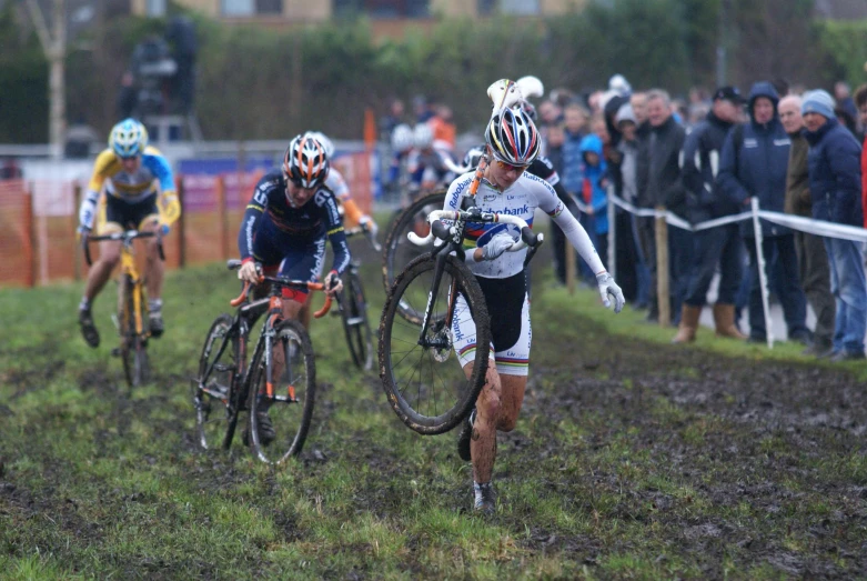 men on bicycles race each other down the dirt track