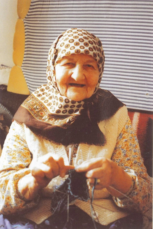 an elderly woman sitting down with a camera in her hand