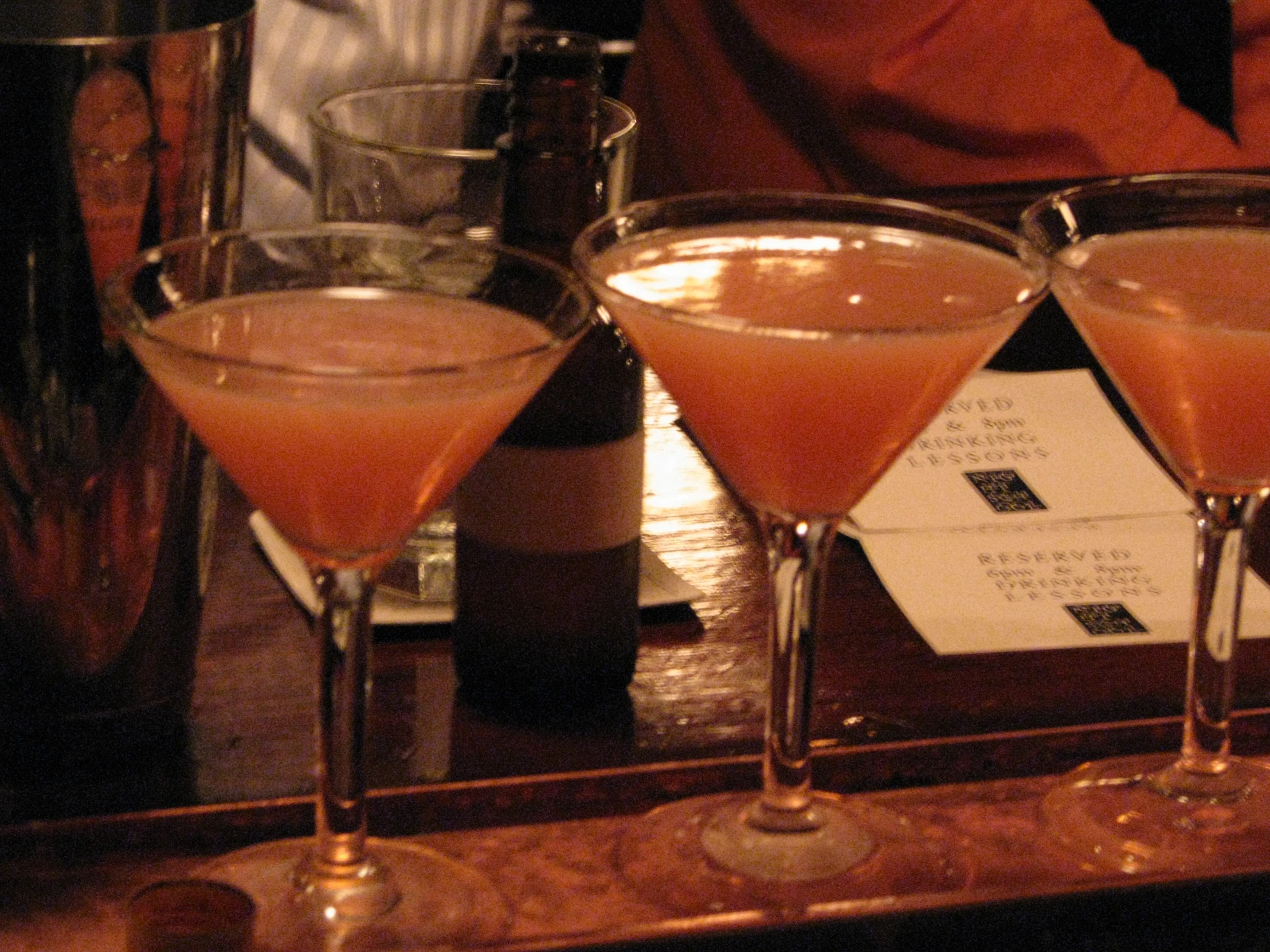 glasses of champagne are sitting on a bar near bottles