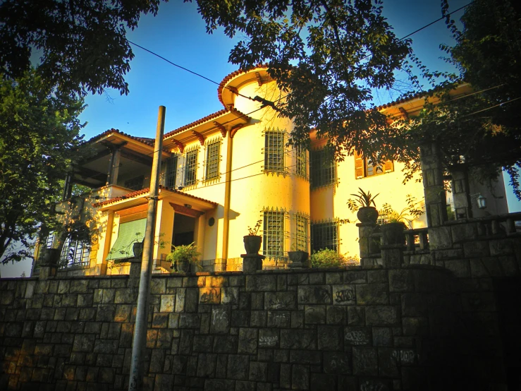 an old building with a tall brown gate and grass