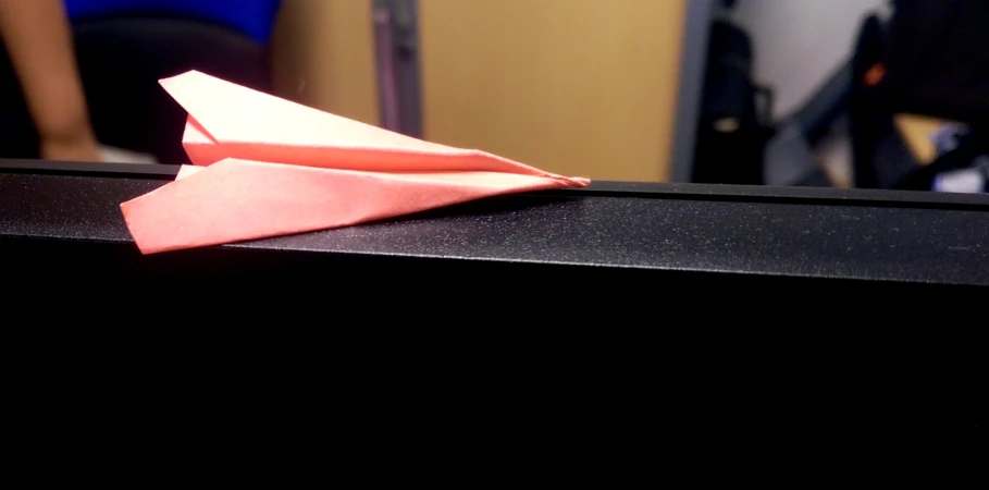 the pink paper is on top of the black table