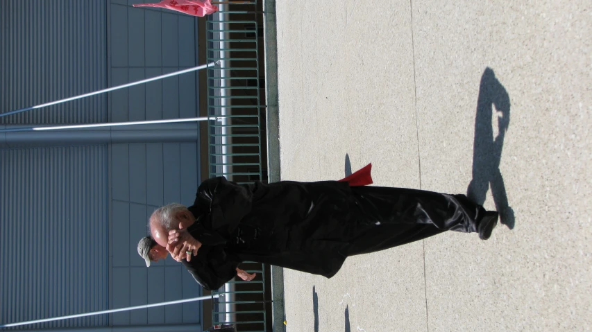 an older man standing next to a metal fence