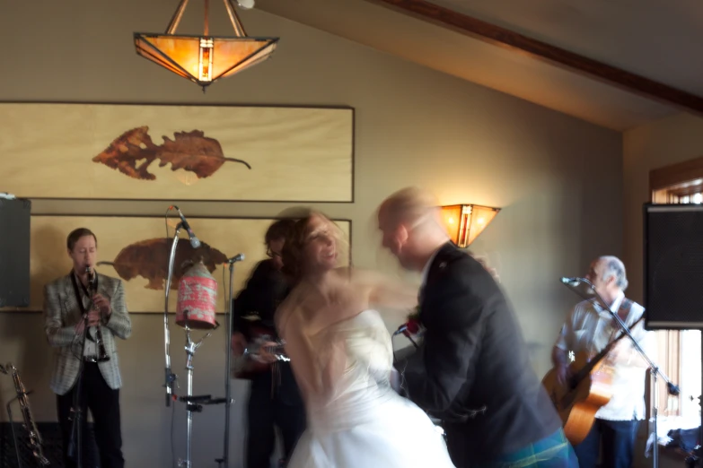 this bride and groom dance to a song while friends watch